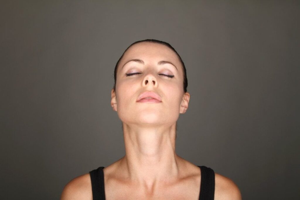 Žena radi joga vežbe za vrat.