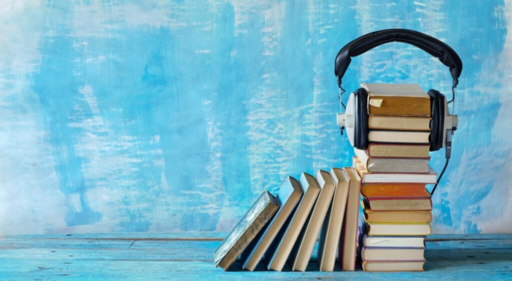 knjige poslagane vertikalno,na kojia su slušalice, kao simbol da je literatura hrana za mozak