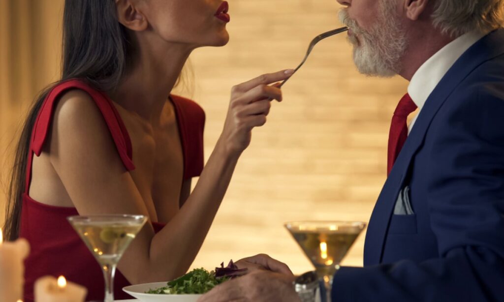 Mlada žena na večeri sa starijim muškarcem.