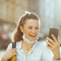 zena se smeje dok gleda u telefon