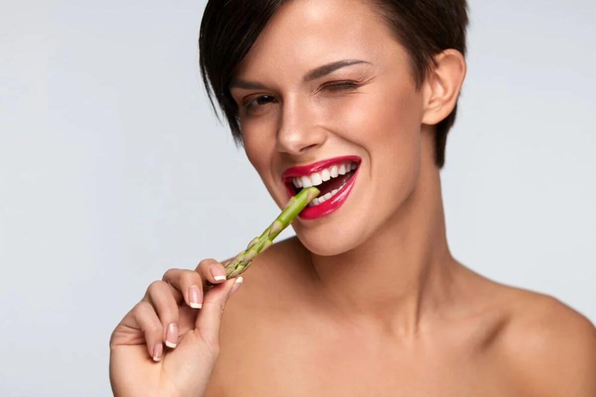 Žena jede šparglu