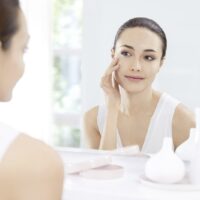 devojka neguje kozu i gleda se u ogledalu