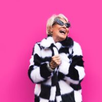 nasmejana zena u kariranom kaputu