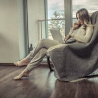 devojka sedi u fotelji sama