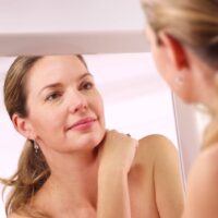 zena se gleda u ogledalu