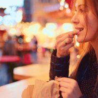 devojka jede kestenje na ulici