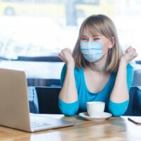 devojka sa maskom gleda u kompjuter