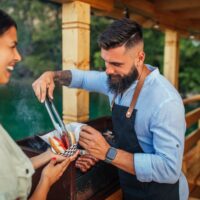 muskarac stavlja pljeskavicu devojci u ruku