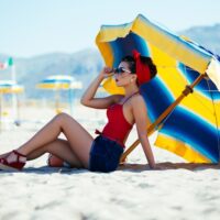 zena na plazi ispod suncobrana