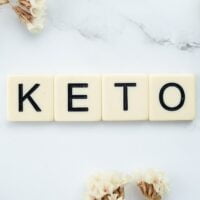 KETO reč ispisaan kockicama koje se koriste u društvenoj igri scrable. Postavljene su na mermernom stolu.
