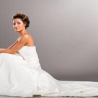 Mlada u četrdesetim, pozira u beloj venčanici