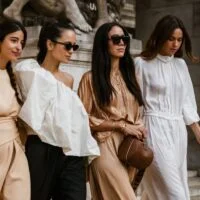 Četiri elegantne devojke,odevene u upečatljive trendi kombinacije poziraju na ulici