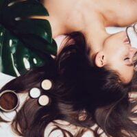 Devojka leži, a oko nje je na podlozi rasuta bujna, duga, tamno smeđa kosa.