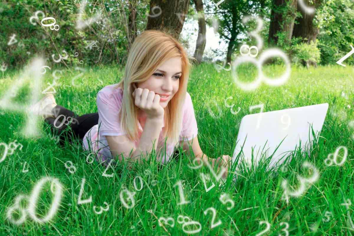 Devojka leži u travi, gleda u lap top, a oko nje figurativno lete brojevi.