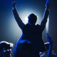 Poslovni muškarac diže ruke u znak pobede