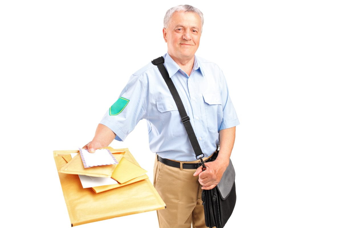 Poštar, sa torbom preko ramena, drži poismene pošiljke u desnoj rci