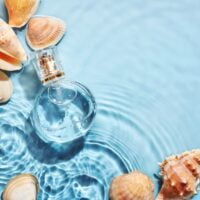 Svežina parfema, bočica u morskoj vodi i školjke