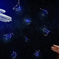 Muška ruka pružena ka ženskoj, u pozadini slike su zodijak sazvežđa.