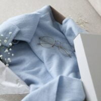 Plavi džemper od kašmira, u luksuznoj kutiji, umotan u takozvani svileni papir