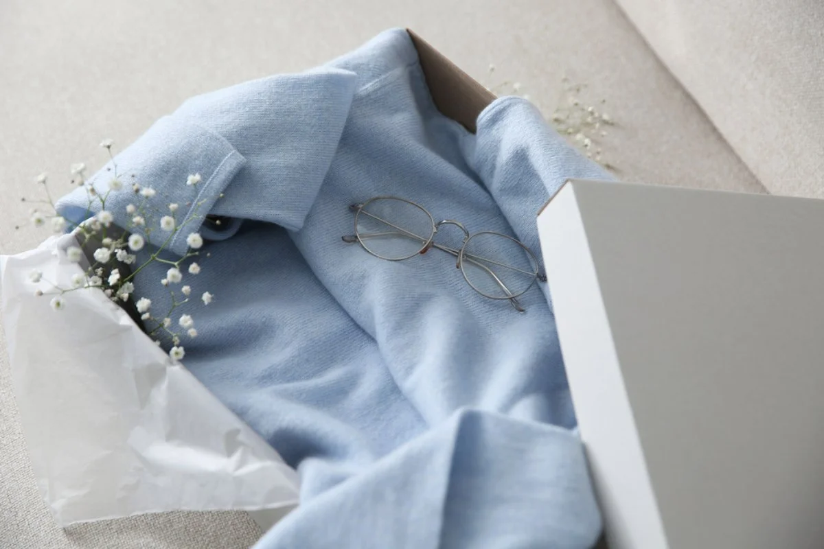 Plavi džemper od kašmira, u luksuznoj kutiji, umotan u takozvani svileni papir