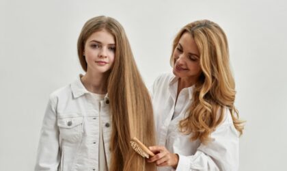 Majka češlja ćerkinu dugu kosu.