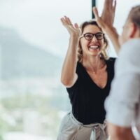 Muškarac i žena bacaju pet i raduju se.