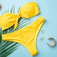 Žuti bikini, list palme, naočare za sunce.