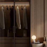 Orman u spavaćoj sobi, koji je otvoren, a unutra se vide jakne i mantil koji vise na ofingerima.