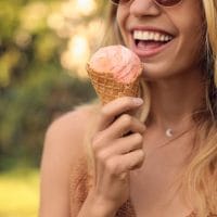Nasmejana devojka jede sladoled.