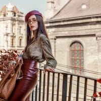 Moderna devojka u bordo kožnoj suknji.