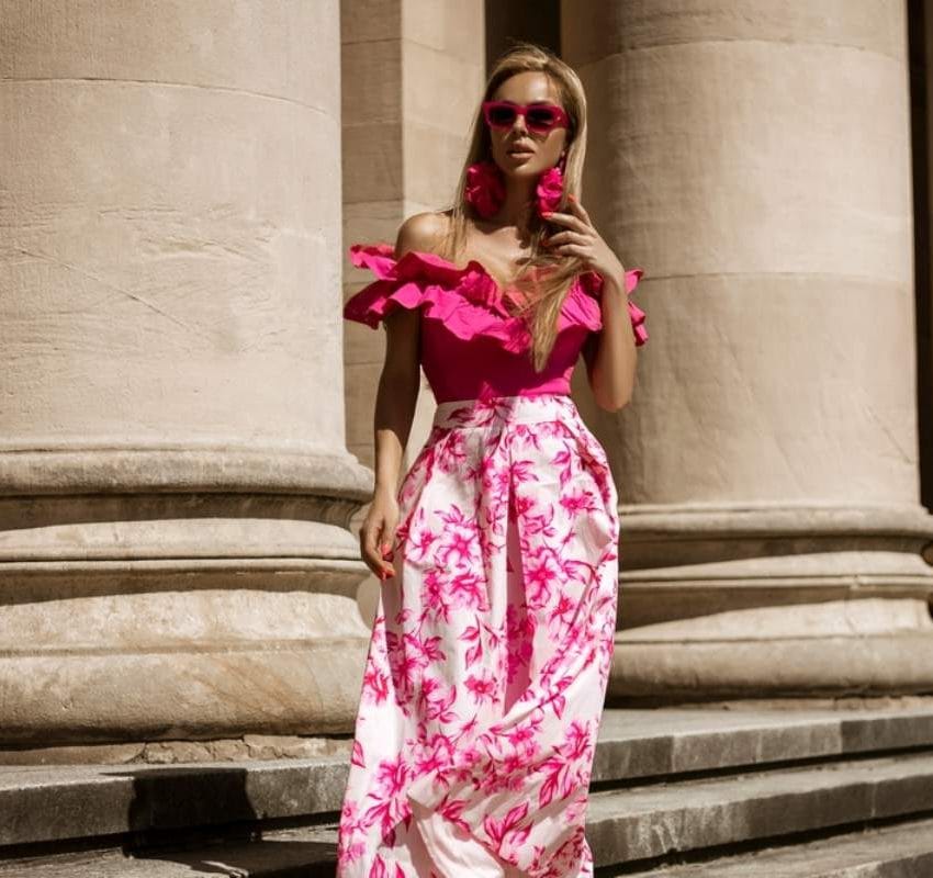 Devojka nosi modernu roze dugu haljinu.