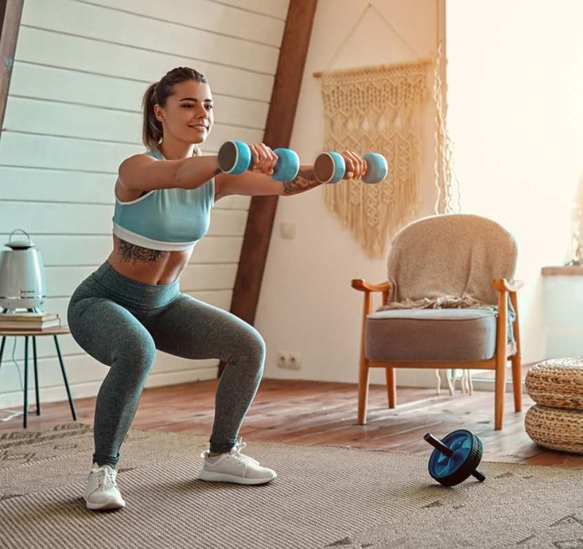 Devojka koja vežba u sobi sa tegićima.