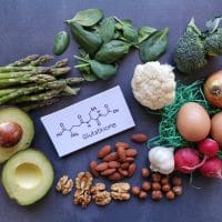 Avokado, brokoli, karfiol, beli luk i, jaja i na papiru je napisana formula glutationa i reč glutation.