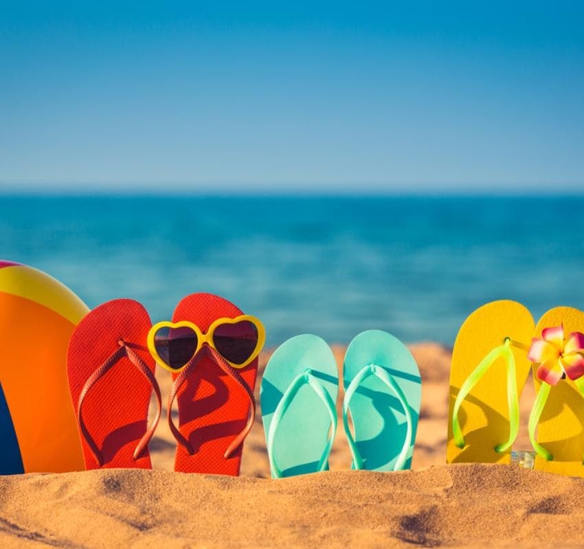 raznobojne japanke poređane na plaži.