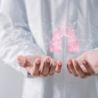 Doktor koji u rukama drži ilustraciju pluća