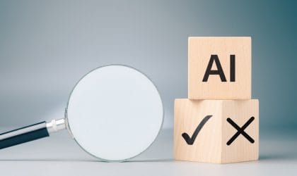 Dva kocke, na jednoj piše AI, a na donjoj kocki, na jednoj strani štrikla, a na drugoj znak za netačno. Pored je lupa.