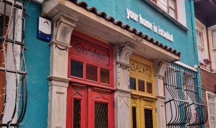 Zgrada i živopisni ulazi obojeni u oker i narandžasto.