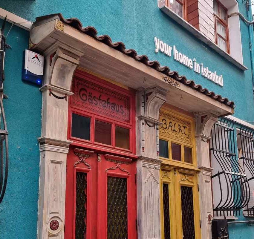 Zgrada i živopisni ulazi obojeni u oker i narandžasto.