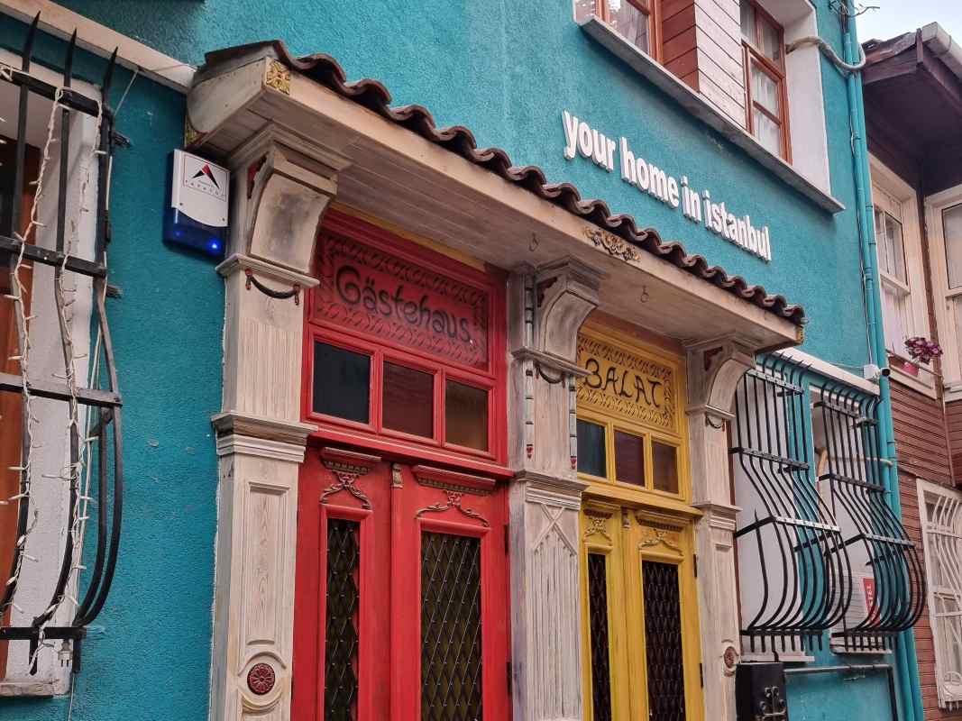 Zgrada i živopisni ulazi obojeni u oker i narandžasto.