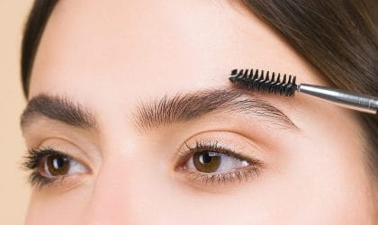 Žena začešljava obrve i učvršćuje naoseći gel, četkicom koja liči na maskaru.