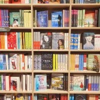 Polica sa knjigama, gde je jedna od knjiga književnice Ani Erno. Na koricama jedne od knjiga se vidi njen lik.