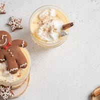 Koktel u čašama, okolo su novogodišnji ukrasi i grančice jelke.