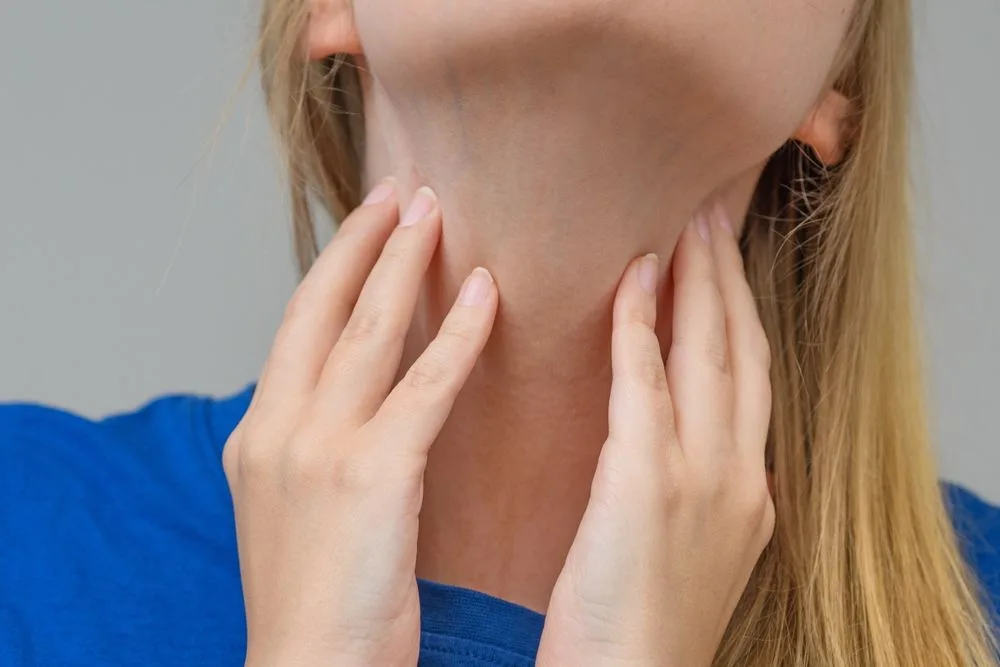 Devojka drži ruke na vratu u predelu limfnih čvorova koji su otečeni.