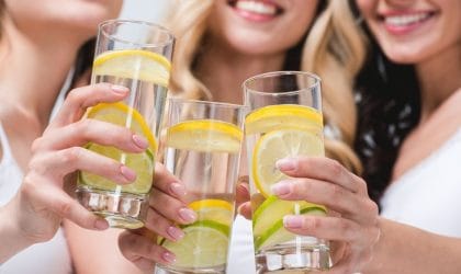 Tri žene nazdravljaju čašama sa vodom u kojoj su kolutovi limuna.