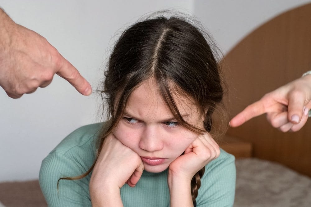 Tužna i ljuta devojčica koju roditelji grde.