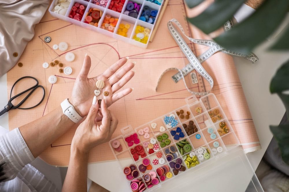 Žena bira među mnoštvom dugmeta za ušivanje.