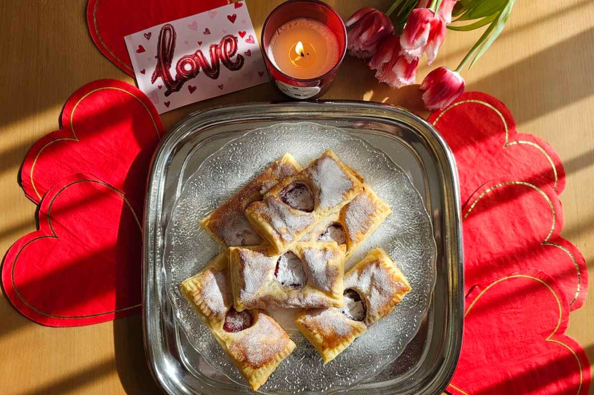 Ljubavna pisma od lisnatog testa, na kome je napravljen otvor oblika srca u kome se vidi crveni džem. Poslužena su na srebrnom poslužavniku koji stoji na crvenim srcima isečenim od papira. U pozadini se vidi poruka i romatična sveća.