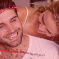 Par, zagrljaj, strast, oko glave im lebde iscrtana srca.