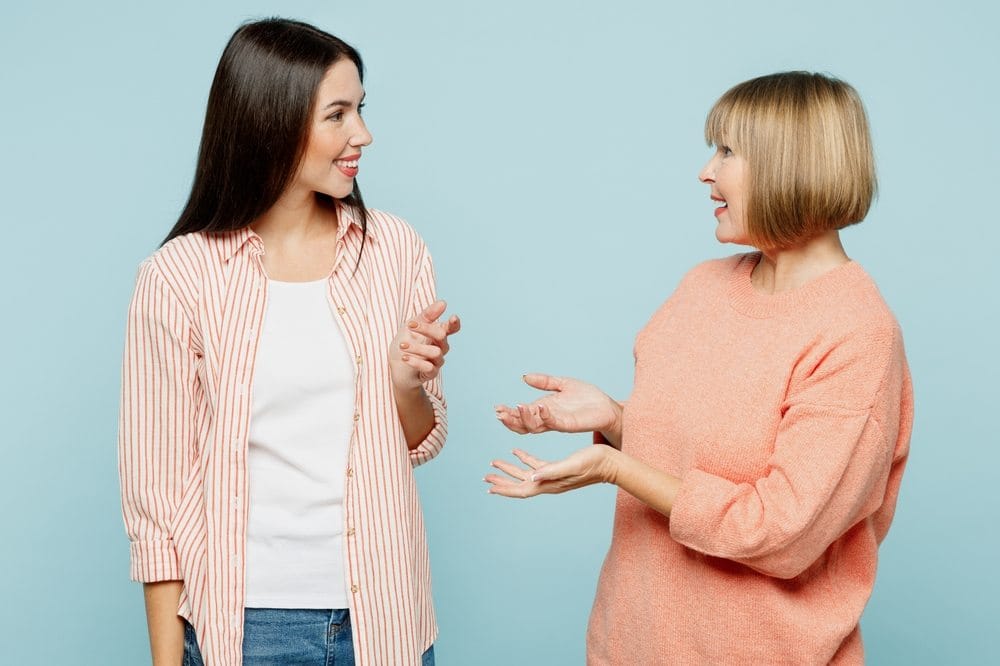 Dve srećne i raspoložene žene u prijatnom razgovoru.