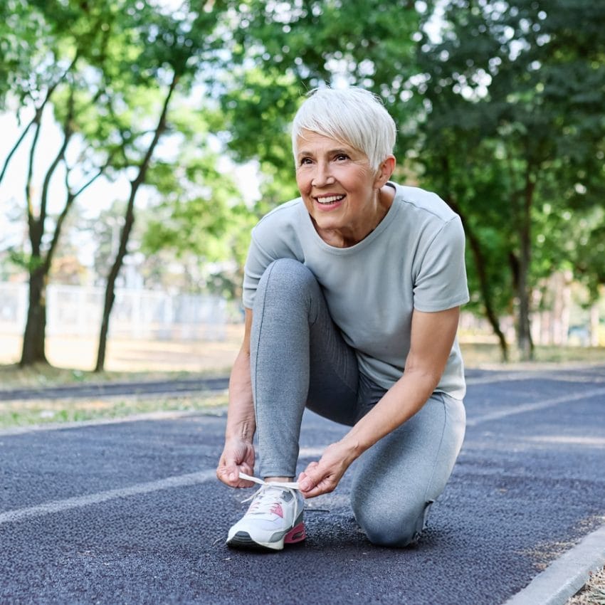 Starija žena u sportskoj opremi se sprema za džoging.
